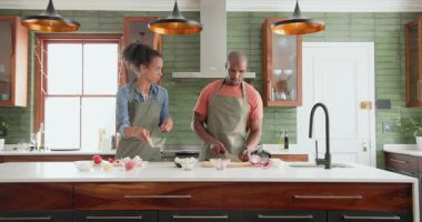 Çeşitli çiftler modern mutfakta yemek hazırlıyor, sebze doğruyor ve evde organize oluyorlar. Yemek pişirme, takım çalışması, aşçılık, yaşam tarzı, gurme, sağlıklı
