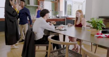 Çeşitli arkadaşlar mezuniyetten sonra yemek masasında toplanıp püskülleri inceleyip gülüyorlar. Kutlama, dostluk, başarı, yoldaşlık, modern, samimi, canlı