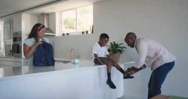 Mutfakta çeşitli aile sabah rutinleri, tezgahta oturan, evde oturup fotokopi çeken çocuk. yemek, kahvaltı, yaşam tarzı, yerli, çocuklar