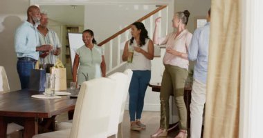 Bir grup farklı arkadaş evde kutlama yapıyor, şarap dolduruyor ve sohbetin tadını çıkarıyorlar. Kutlama, arkadaşlık, toplanma, parti, mutluluk, şerefe