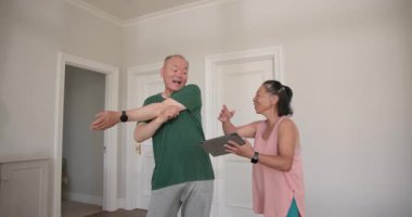 Kıdemli çift antrenman rehberliği için tablet kullanarak evde fitness rutininin keyfini çıkarıyor. Yaşlılar, egzersiz, refah, teknoloji, dijital fitness, sağlık