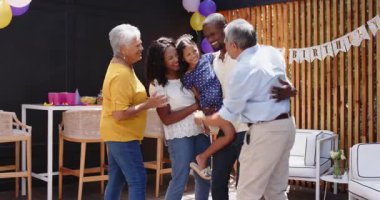 Çeşitli aileler doğum gününü kutluyor, evde balonlar ve dekorasyonlarla neşeyle dans ediyor. Kutlama, parti, festival, mutluluk, dans