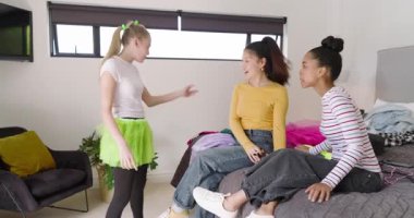 Çeşitli arkadaşlar yatak odasına girerken beyaz arkadaşları selamlıyor, selfie çekiyorlar, allık sürüyorlar. Arkadaşlık, çeşitlilik, eğlence, yaşam tarzı, günlük, samimi, iç mekan