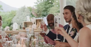 Gelinlik giymiş gelin masanın ucunda, damat şampanya kadehlerini kaldırıyor konukları yudumluyor. Kutlama, yoldaşlık, zarafet, neşe, çeşitlilik, sofistike, boş zaman