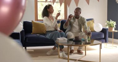 Çeşitli çiftler evde kutlama yapıyor, rahat oturma odasındaki kanepede pasta ve şarabın tadını çıkarıyorlar. Kutlama, yaşam tarzı, rahatlama, arkadaşlık, mutluluk, aşçılık