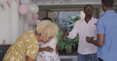 Farklı arkadaşlar evde kutlama yapıyor, parti patlayıcıları tutuyor ve evde heyecandan alkışlıyorlar. Kutlama, mutluluk, şenlik, kahkaha, birliktelik, eğlence