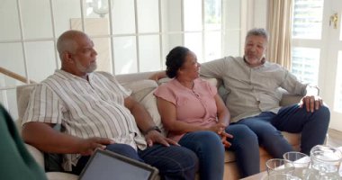 Evdeki kanepede oturan kıdemli arkadaşlar, canlı sohbetler ediyorlar. Yaşlılar, dostluk, rahatlama, rahatlama, arkadaşlık, bağlanma.