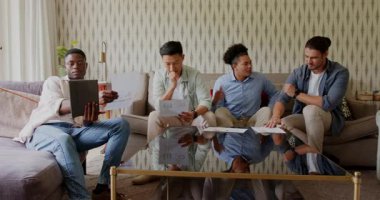 Çeşitli iş arkadaşları tablet kaydırarak gri koltukta tablet değiş tokuşu yapıyor sonra da yumruk tokuşturuyorlar. İşbirliği, takım çalışması, profesyonel, modern, gündelik, çeşitlilik, iletişim