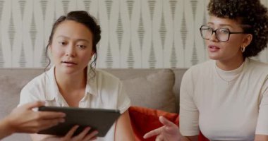 Tablet ve bar tabletlerini kanepede karşılaştıran verileri analiz eden çarşaf, çeşitli bayan meslektaşlar. İşbirliği, takım çalışması, veri analizi, iş gündelik, yenilik, modern, iletişim