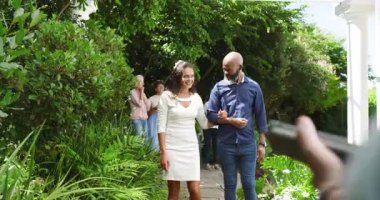 Gelini pergola altında yürürken izleyen misafirler, adam eskort ve resmi tören klasörü. Kutlama, gelenek, zarafet, romantizm, çevre, toplanma, neşe