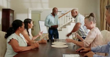 Çeşitli yaşlılar yemek masasının etrafında hediye değiş tokuşu yapıyor, evde özel bir kutlama yapıyorlar. Kutlama, çeşitli kıdemli arkadaşlar, gelenek, hediyeler, mutluluk, toplanma