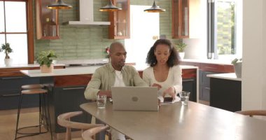 Çeşitli çiftler evde dizüstü bilgisayar kullanırken planları tartışıyor, takım çalışmasından keyif alıyorlar. İşbirliği, planlama, teknoloji, ilişki, ev ofisi, dijital