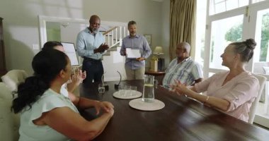 Kıdemli adamın başarısını kutlayan farklı yaşlılar, evlerinde ödülle neşeli anları paylaşıyorlar. Kutlama, mutluluk, destek, başarı, birliktelik