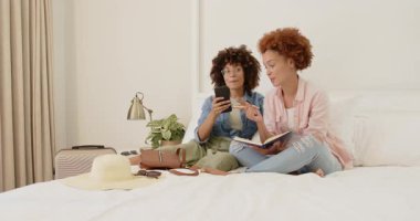 Yatağa bavul hazırlıyorlar, neşeli lezbiyen çift evde tatile hazırlanıyor. Seyahat, tatil, hazırlık.