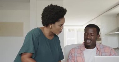 Evde dizüstü bilgisayar kullanan, gülümseyen ve eğlenen bir çift. teknoloji, yaşam tarzı, yurtiçi, mutluluk, boş zaman, iletişim