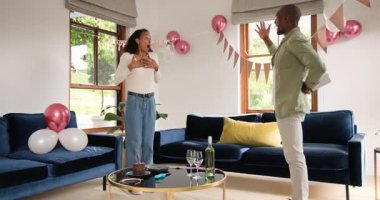 Çeşitli çiftler evde kutlama yapmak için balonlu ve pankartlı oturma odalarını dekore ediyorlar. parti, dekorasyon, şenlik, mutluluk, neşe