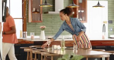 Mutfak masasında şarap ve mumlarla kutlama yapan bir kadın. Yemek, şenlik, akşam yemeği, ortam, güzel yemekler, hazırlık.