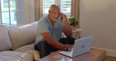 Evde dizüstü bilgisayar kullanan kıdemli bir adam, düşünceli bir ifadeyle işine konsantre oluyor. Yaşlılar, teknoloji, çalışma alanı, konsantrasyon, telekomünikasyon, düşünme