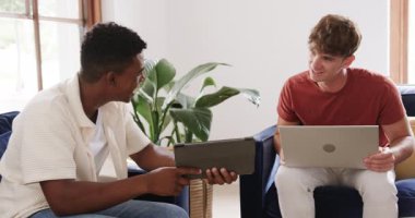 Çeşitli erkek arkadaşlar tableti arkadaşlarına doğru çeviriyor ve evdeki proje için dizüstü bilgisayara not alıyorlar. İşbirliği, takım çalışması, teknoloji, iletişim, modern, gündelik, iç mekan
