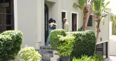 Genç çocuk modern evin dışında sevinçle koşuyor, heyecanla kutluyor. Mutluluk, kutlama, bahçede, gençlik, modern yaşam, enerji