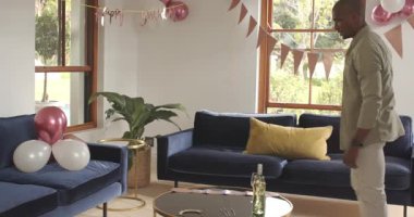 Evde doğum günü kutlaması için balonlar ve afişlerle oturma odasını dekore etmek. Parti, şenlik, dekorasyon, iç mekan, ortam, renkli