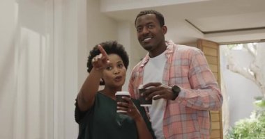 Çeşitli arkadaşlar evde kahvenin keyfini çıkarıyorlar, gülümsüyorlar ve mutlu bir şekilde sohbet ediyorlar. Arkadaşlık, rahatlama, sohbet, eğlence, içecek, yaşam tarzı.