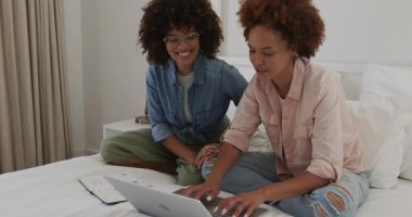 Çift cinsiyetli lezbiyen çift dizüstü bilgisayar ve akıllı telefon kullanıyor, evde birlikte vakit geçiriyorlar. ev, ilişki, bağ, teknoloji, yatak odası, rahatlama