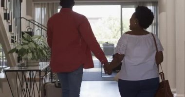 Eve bavullarla gelen, çeşitli çiftler oturma odasında sevinçle kucaklaşıyorlar. Seyahat, eve dönüş, kucaklaşma, mutluluk, paketleri açma, birleşme