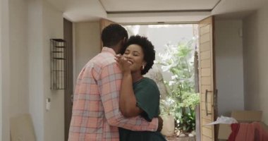 Çeşitli çiftler evde kutuları açıyor, gülümsüyor ve yeni alanların tadını çıkarıyorlar. Taşınma, taşınma, ev sahipliği, aile, mutluluk, kutlama