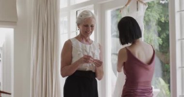 Çeşitli kadınların önlük giymesi, pudra sürmesi, düğün hazırlıkları sırasında takıları göstermesi. Zarafet, kadınlık, kutlama, uyum, incelik, lüks, sanatçılık