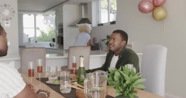 Arkadaşlar evde brunch 'ın tadını çıkarıyorlar, sohbet ediyorlar ve içki içiyorlar. Arkadaşlık, toplanma, yiyecek, içecek, sosyalleşme, yaşam tarzı.