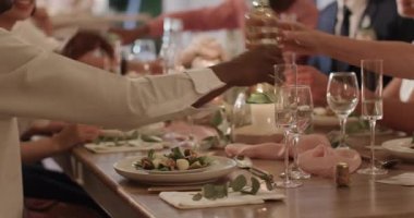 Çeşitli düğün davetlileri su sürahisinin önünden geçip salata yerken gelin masada damada kadeh kaldırıyor, kopyalama uzayı. Zarif, kutlama, sosyal, ambiyans, sofistike, konukseverlik, kibarlık