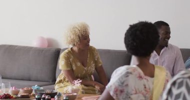 Kadınlar evde abur cubur ve balonlarla eğleniyor. Kutlama, çeşitlilik, mutluluk, toplanma, şenlik, eğlence