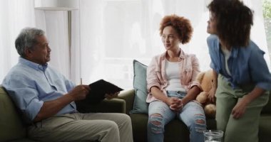 Aynı cinsiyetten lezbiyen çift kanepede oturup evdeki rahat oturma odasında terapistle konuşuyor. Danışmanlık, psikoloji, terapi, akıl sağlığı, ilişki, iletişim