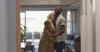 Çeşitli çiftler, evlerinde bavullarını oturma odasında neşeyle kucaklaşıyorlar. Seyahat, tatil, ilişki, bagaj, aşk, mutluluk