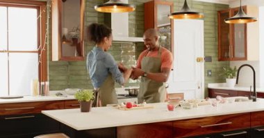 Modern mutfakta birlikte yemek pişiren, önlük giyen ve evde eğlenen farklı çiftler. Yaşam tarzı, takım çalışması, yerli, aşçı, ilişki