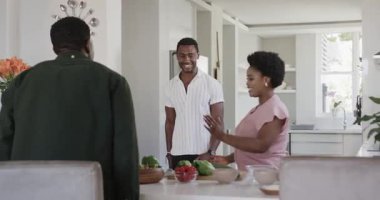 Hediye değişimi, farklı arkadaşlar modern mutfakta gülümsüyor, anı paylaşıyorlar, evde. Arkadaşlık, kutlama, neşe, daire, mutluluk, çeşitlilik