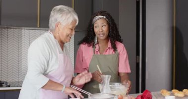 Çeşitli aileler mutfakta birlikte yemek pişiriyor, kaliteli zaman geçiriyor ve evde ikramlar hazırlıyorlar. Beraberlik, aşçılık, kaynaşma, ev yapımı, yemek pişirme, tatlı