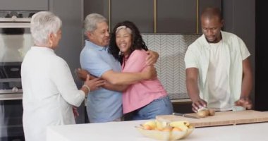 Mutfakta, çok nesilli çeşitli aile bağları ve evde birlikte yemek pişirirken gülüşmeler. Beraberlik, mutluluk, aşçılık, ev, gelenek