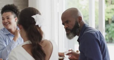 Çeşitli arkadaşlar yemek masasında oturup yemek tadıp sohbet ediyorlar. Sosyalleşme, kutlama, zarafet, bağlantı, eğlence, yaşam tarzı, ambiyans