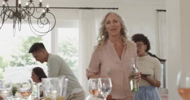 Çeşitli arkadaşlar gelir ve selamlaşır, panoları yerleştirir, şarap şişelerini parlak yemek odasına yerleştirirler. Kutlama, dostluk, zarafet, sosyalleşme, neşe, misafirperverlik, samimiyet.