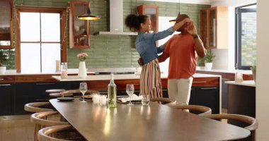 Modern mutfakta kucaklaşan çeşitli çiftler, evde özel bir anı neşe ve sevgiyle kutluyorlar. Romantizm, mutluluk, birliktelik, yaşam tarzı, ev, ortaklık