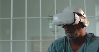 Kıdemli adam evde sanal gerçeklik deneyiminin tadını çıkarıyor, gülümsüyor ve etkileşimde bulunuyor, kopyalama alanı. Yaşlılar, teknoloji, dijital, VR, yenilik, etkileşimli