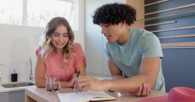 Genç çift kadehlerini mutfakta kaldırıyor, gülümsüyor ve evde birlikte eğleniyorlar. Kutlama, mutluluk, romantizm, yaşam tarzı, ortaklık, birliktelik