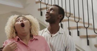 Adam gülüyor ve merdivenlerin yanında arkadaşıyla konuşuyor. çeşitli arkadaşlar, sohbet, mutluluk, oturma odası, gündelik, bağlantı