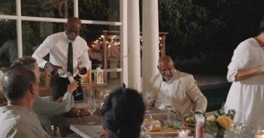 Düğünde, arka bahçedeki yemek partisinde, yaşlı çiftler paylaşırken. Kutlama, toplanma, sosyalleşme, arkadaşlık, arka bahçede mutluluk.