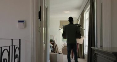 Taşındıktan sonra, Asyalı kadın ve Afrikalı Amerikalı erkek kutuları açıyor ve koridorda yastıkları paylaşıyorlar. Yer değiştirme, işbirliği, paketleri açma, yerli, yaşam tarzı, gündelik, modern