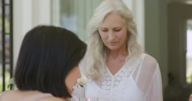 Üst düzey beyaz anne, teras masasındaki Çinli arkadaşına çaydanlıktan çay dolduruyor müstakbel gelini karşılıyor. Öğleden sonra, kutlama, zarafet, gelenek, arkadaşlık, samimiyet, samimiyet