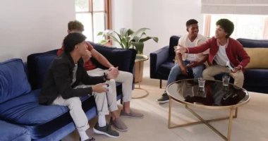 Çeşitli erkek arkadaşlar, oturma odasında kontrolörleri tutup donanma koltuklarına yaslanarak galibiyeti kutluyor. Sıradan, yoldaşlık, takım çalışması, eğlence, eğlence, eğlence, modern, canlı