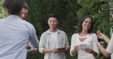 Asyalı nikah memuru tabletinde yeminleri ve bahçede yüzüklerini değiş tokuş eden bir çiftten alıntı yapıyor. Aşk, kutlama, zarafet, samimiyet, doğa, gelenek, mutluluk